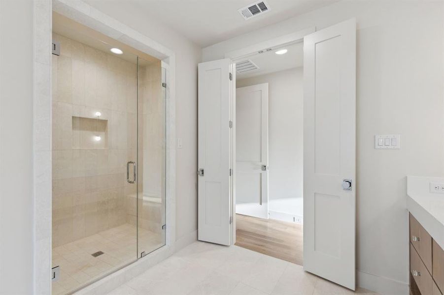 Full bath featuring vanity, a shower stall, tile patterned flooring, and recessed lighting