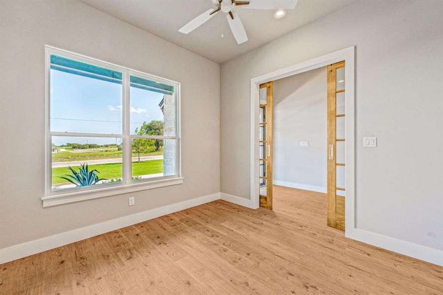 Empty room with light hardwood / wood-style floors and ceiling fan