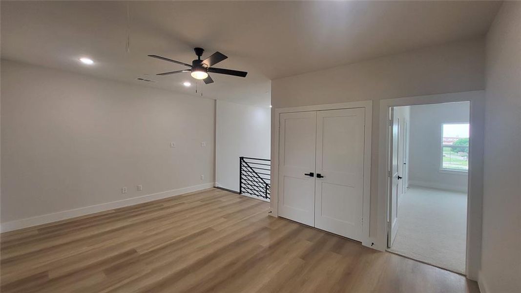 Unfurnished room featuring visible vents, light wood finished floors, baseboards, and ceiling fan