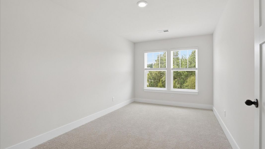 Notable bedroom offering soft carpet, a walk-in closet, and expansive windows overlooking the yard at Marion Square Notable bedroom offering soft carpet, a walk-in closet, and expansive windows overlooking the yard at Marion Square