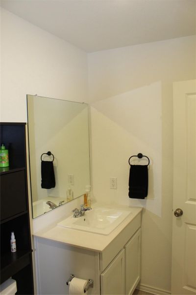 Half bathroom with vanity and baseboards