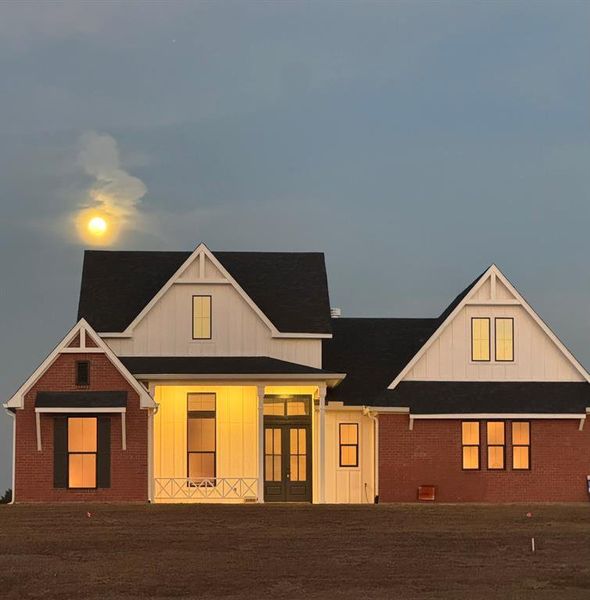 Modern farmhouse with board and batten siding, french doors, and brick siding