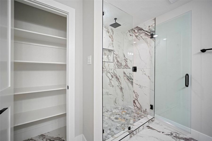 Bathroom featuring a marble finish shower and marble finish floor