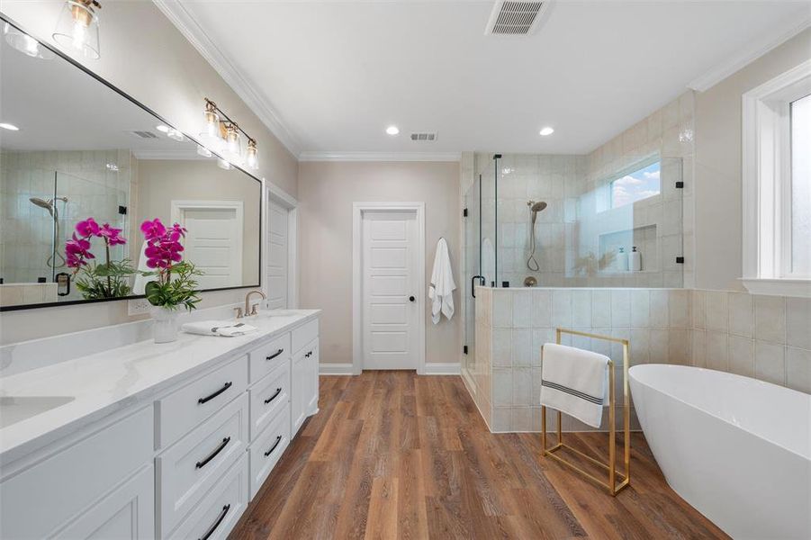 Full bathroom with visible vents, a sink, a shower stall, and ornamental molding