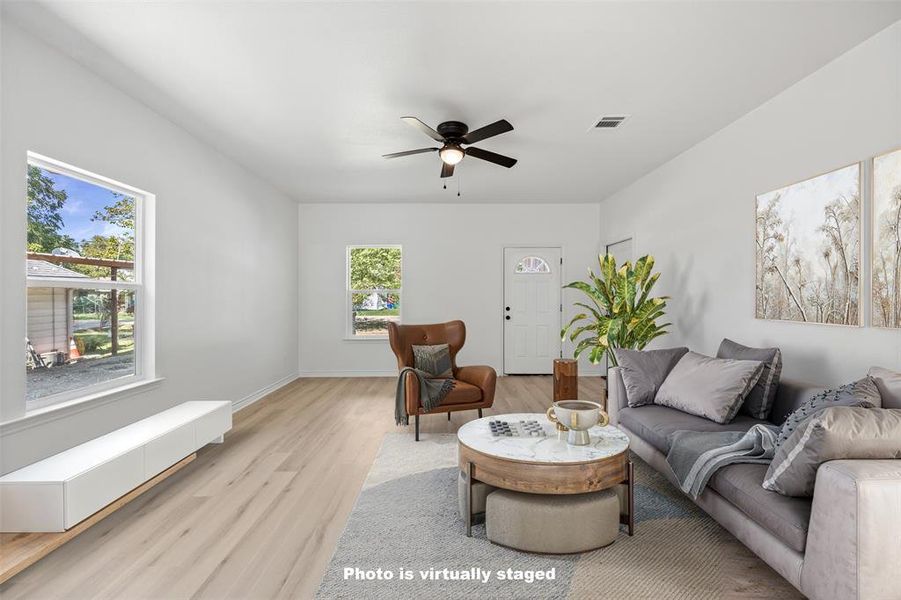 Living area with light wood-style flooring and a ceiling fan