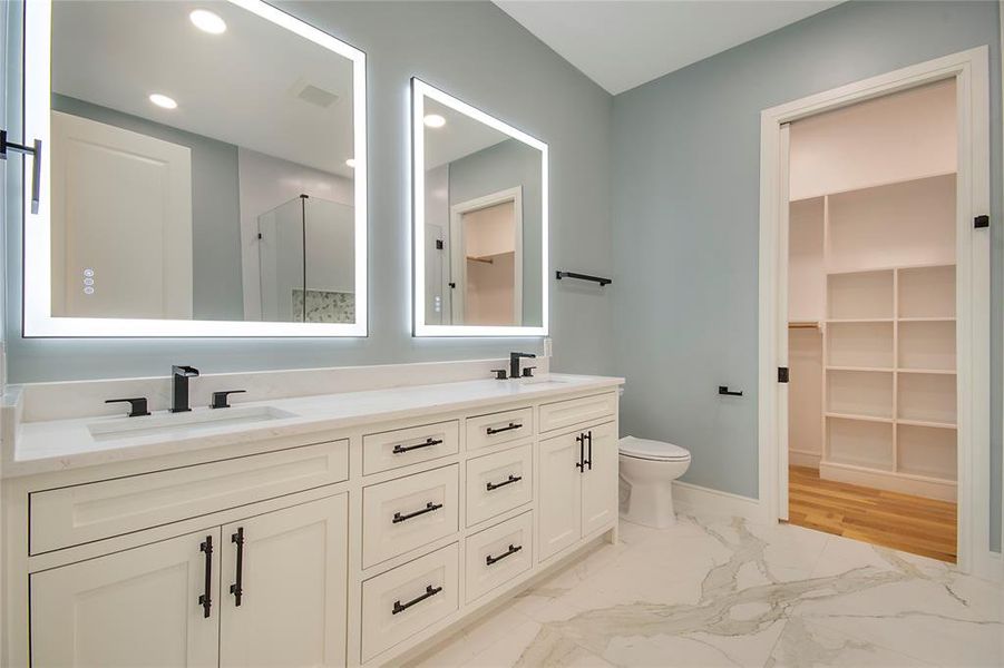 Full bathroom with light marble finish floors, a spacious closet, double vanity, and recessed lighting