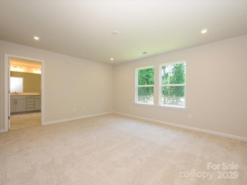 Primary suite with bright windows and an en suite bath. Primary suite with bright windows and an en suite bath.