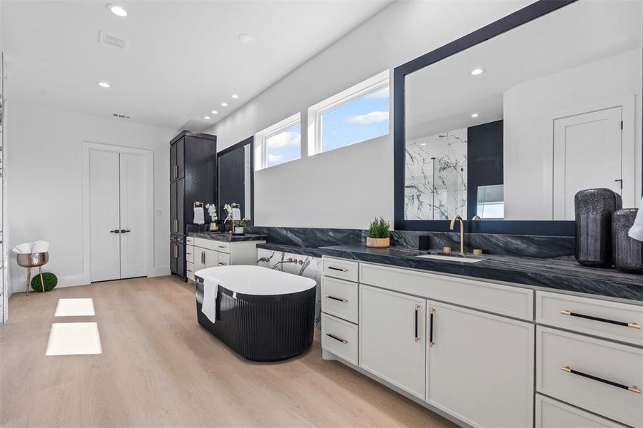 Full bath with a marble finish shower, two vanities, recessed lighting, light wood-style flooring, and a freestanding bath
