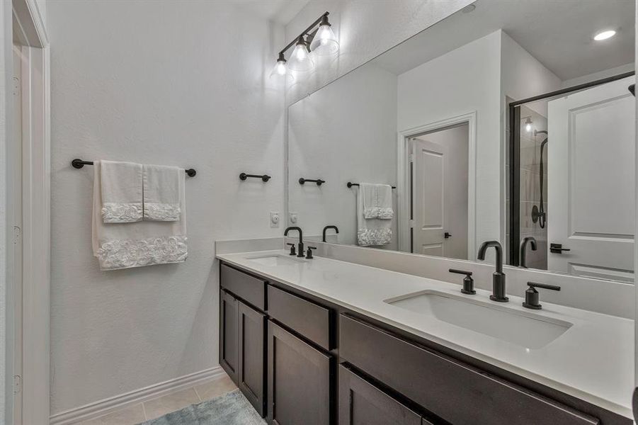 Bathroom with tile flooring, double sink, and vanity with extensive cabinet space