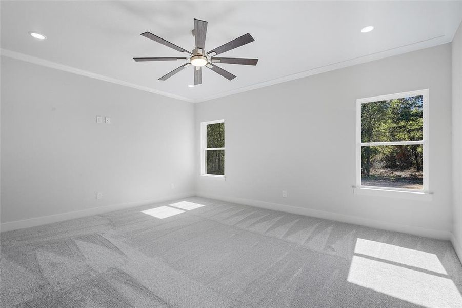 Carpeted spare room with crown molding, plenty of natural light, recessed lighting, and ceiling fan Carpeted spare room with crown molding, plenty of natural light, recessed lighting, and ceiling fan