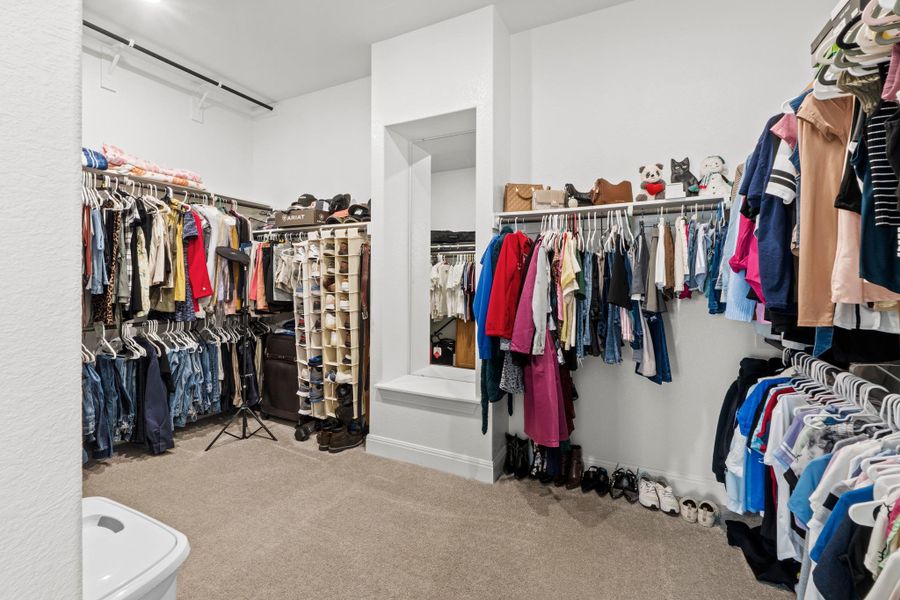 Forget cramped closets; this massive walk-in primary closet is a room unto itself.
