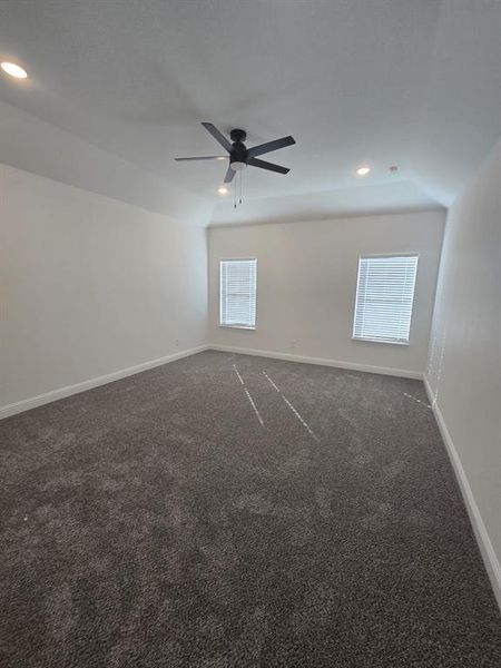 Spare room with dark carpet, recessed lighting, and a ceiling fan