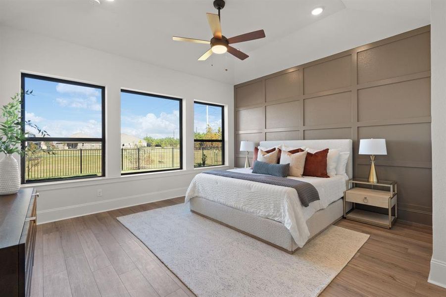 Primary suite with wood accent wall; side wall of windows with a stunning water view