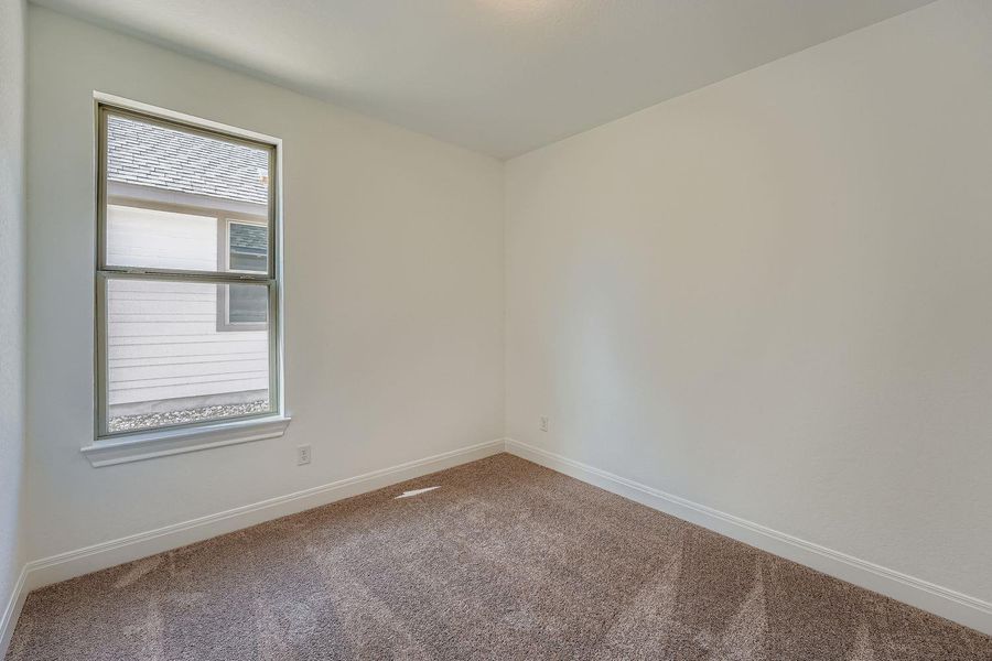 Empty room featuring carpet flooring and baseboards