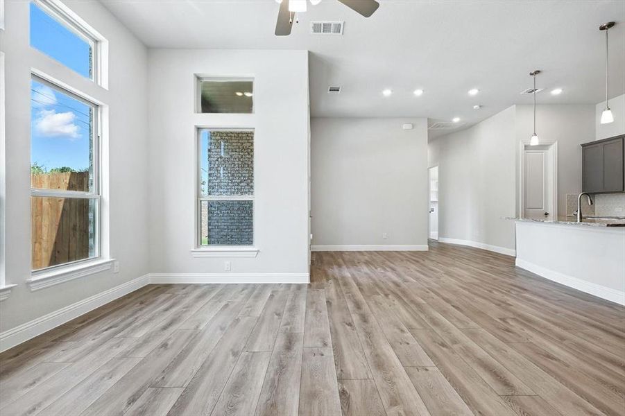 Unfurnished living room featuring a ceiling fan, light wood-style floors, and recessed lighting Unfurnished living room featuring a ceiling fan, light wood-style floors, and recessed lighting
