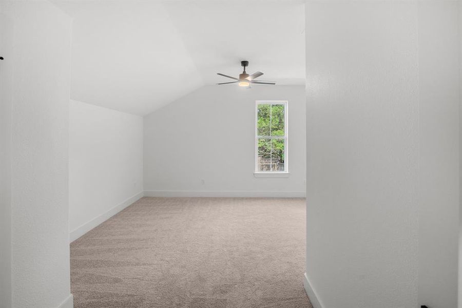 Bonus room with vaulted ceiling, carpet, a ceiling fan, and baseboards Bonus room with vaulted ceiling, carpet, a ceiling fan, and baseboards