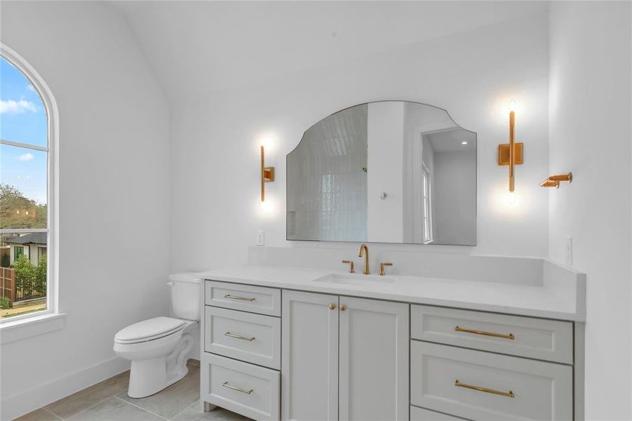 Bathroom with vanity, lofted ceiling, and light tile patterned flooring