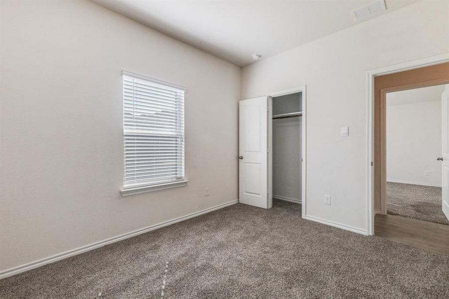 Unfurnished bedroom featuring carpet and a closet Unfurnished bedroom featuring carpet and a closet