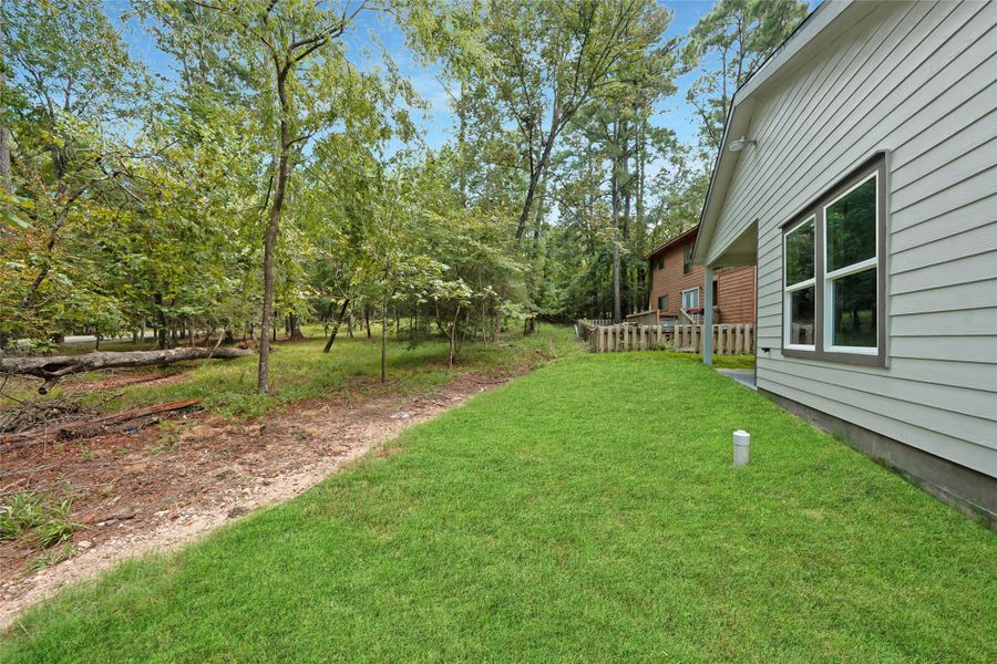 The beautiful lawn beside the house and behind the carport offers a peaceful, well-maintained space, perfect for relaxing or outdoor activities, adding charm and tranquility to the home.