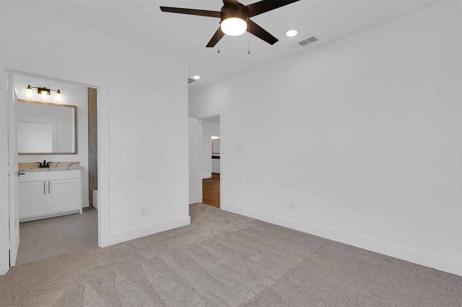 Unfurnished bedroom with carpet flooring, recessed lighting, ensuite bath, and ceiling fan Unfurnished bedroom with carpet flooring, recessed lighting, ensuite bath, and ceiling fan