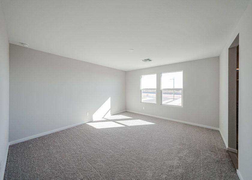 A room with a carpet and windows.