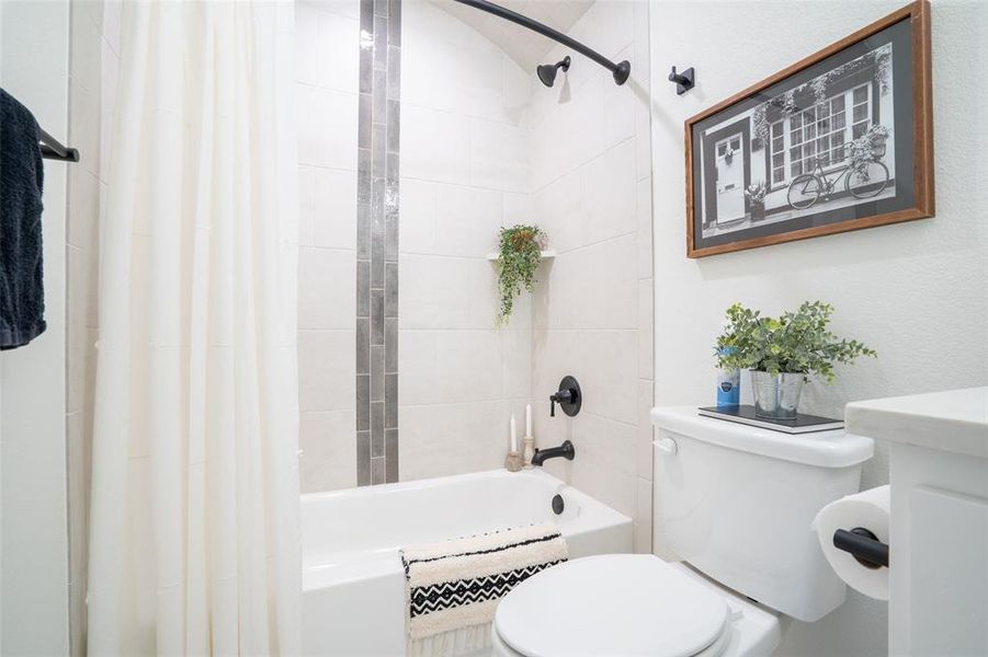Bathroom with toilet and shower / bath combination with curtain Bathroom with toilet and shower / bath combination with curtain