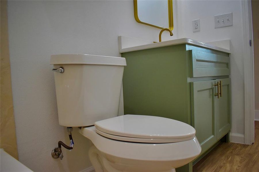 Half bathroom featuring vanity and wood finished floors
