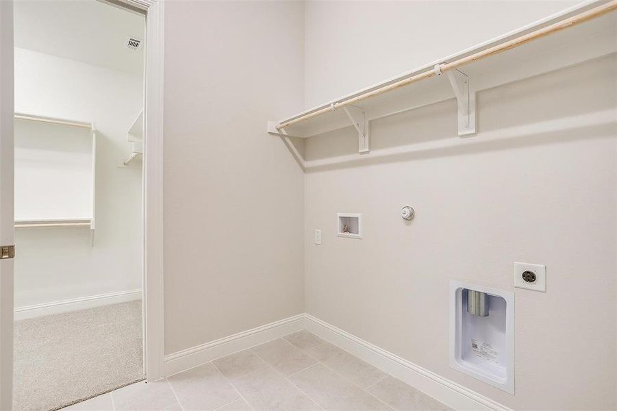 Clothes washing area with electric dryer hookup, gas dryer hookup, hookup for a washing machine, and light colored carpet