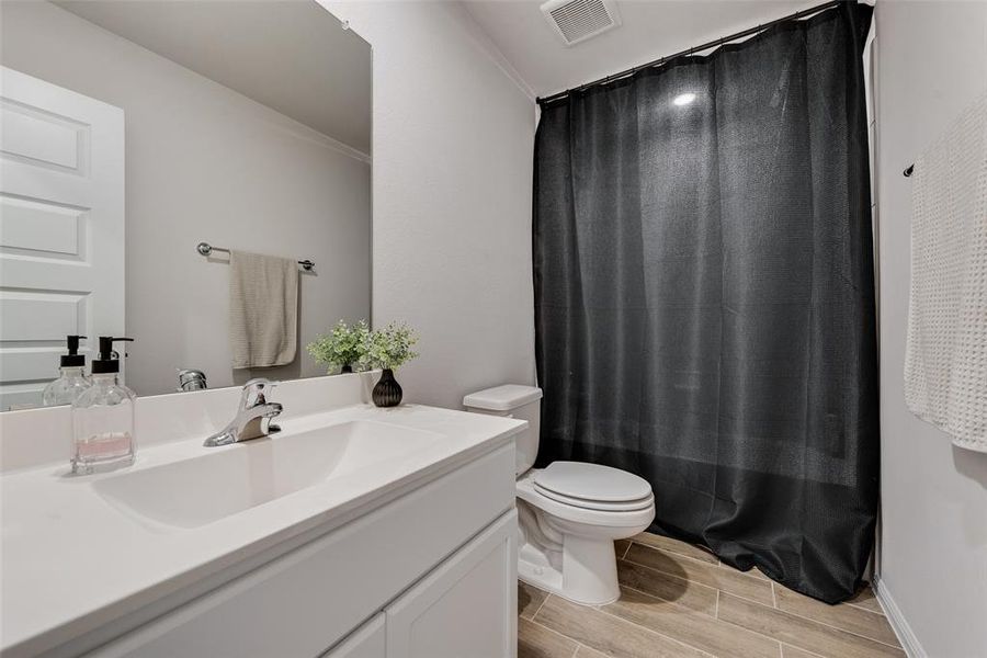 Full bath with wood tiled floors and vanity Full bath with wood tiled floors and vanity