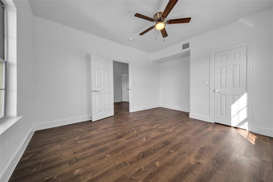 Unfurnished bedroom with dark wood-style floors and a ceiling fan Unfurnished bedroom with dark wood-style floors and a ceiling fan