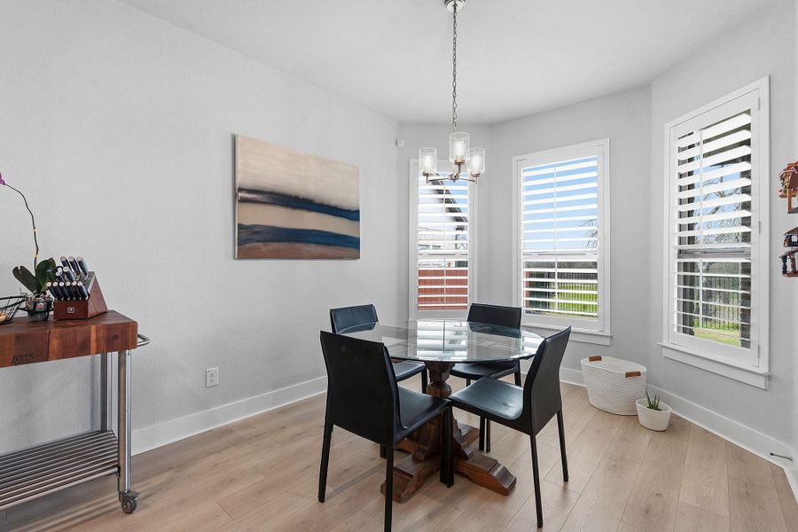 Dining room featuring light wood-style floors and hanging lights