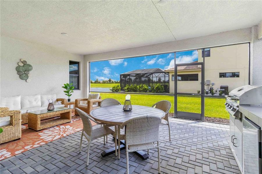 Extended Covered Screened Lanai with Outdoor Kitchen, Wet Sink, and Pavers.