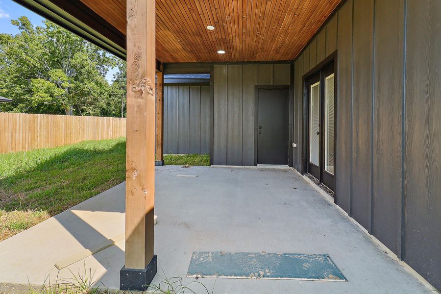 This home features a large covered back porch with the same stained beadboard ceiling.  There is double doors leading from the living room to the back porch and also a door leading to the half bath downstairs for outdoor access.