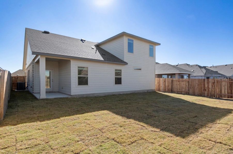 Rear view of house with a fenced backyard, a patio, and roof with shingles