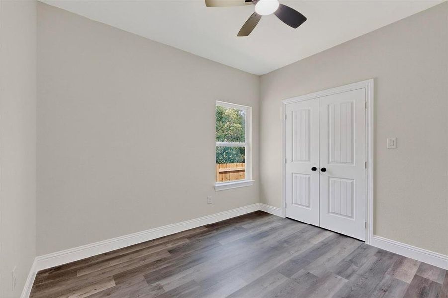Unfurnished bedroom with wood finished floors, a closet, and ceiling fan Unfurnished bedroom with wood finished floors, a closet, and ceiling fan