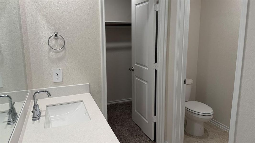 Bathroom vanity featuring a polished chrome faucet, under-mount sink, and light-toned countertop