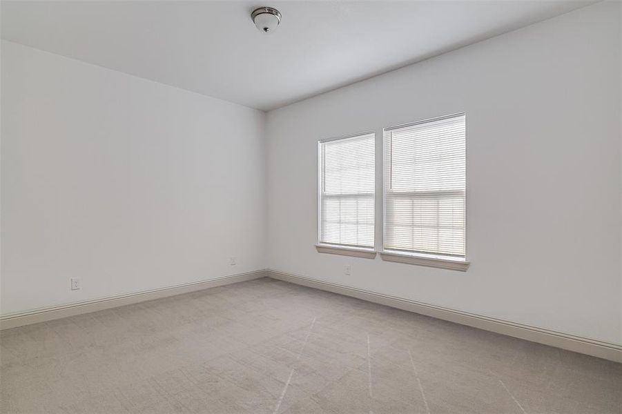 Spare room featuring light carpet and baseboards