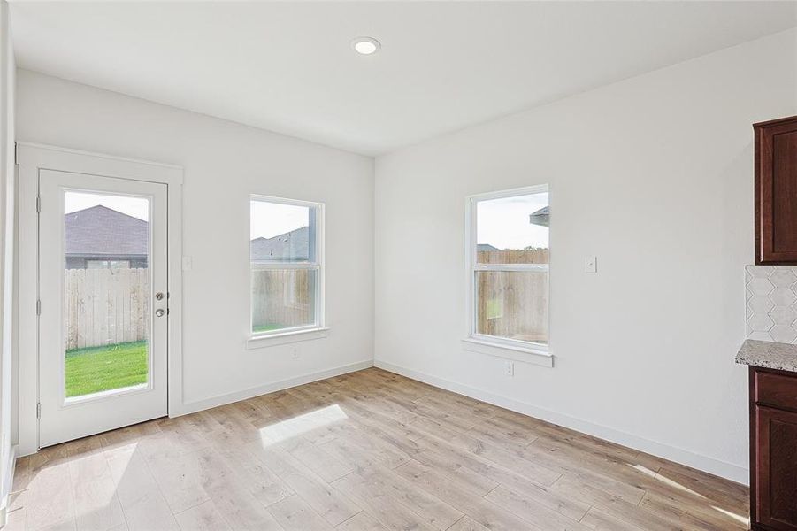 Unfurnished dining area featuring plenty of natural light and light wood-type flooring