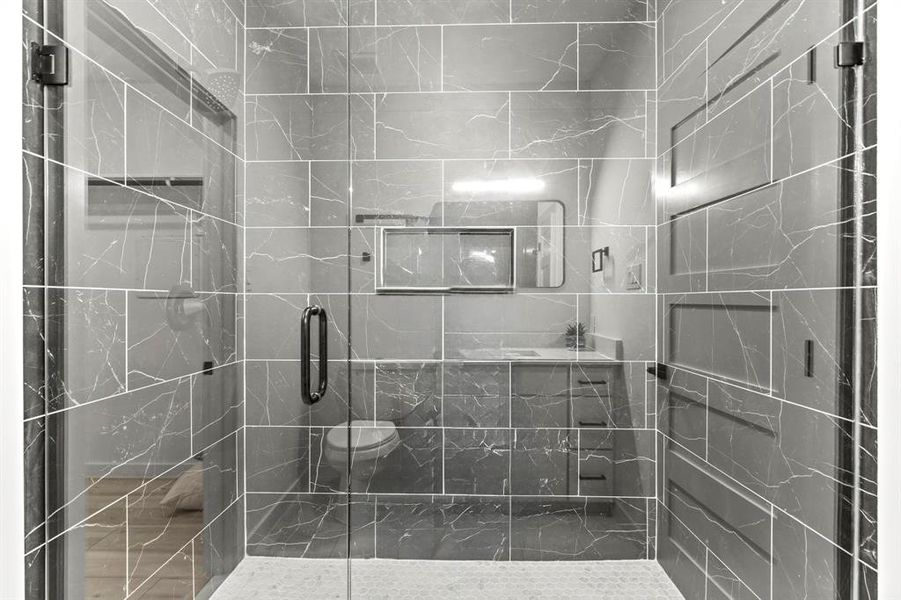 Bathroom featuring a shower stall and toilet Bathroom featuring a shower stall and toilet