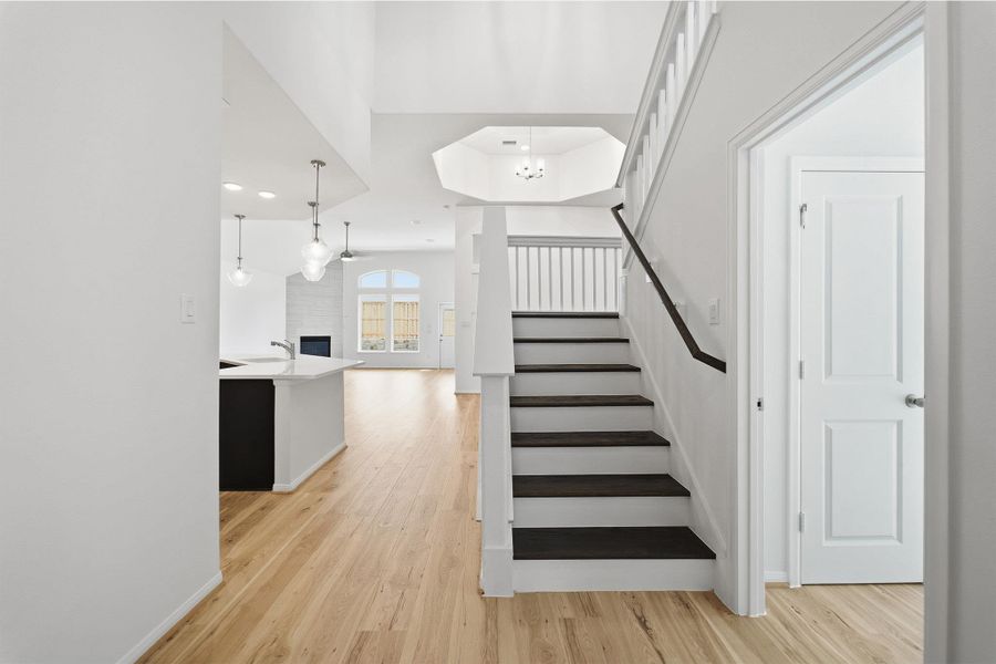 Staircase with wood finished floors, a fireplace, and recessed lighting