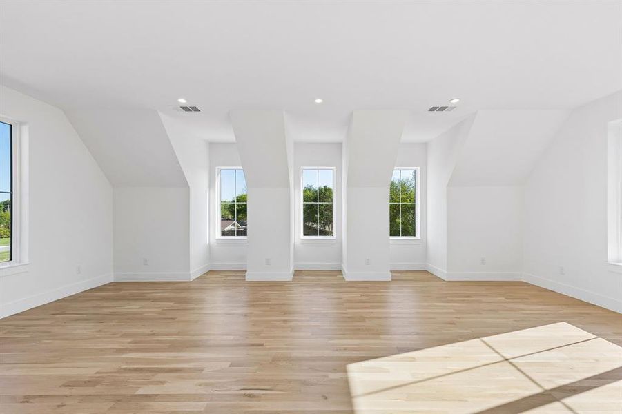 Bonus room featuring vaulted ceiling, light wood finished floors, and recessed lighting