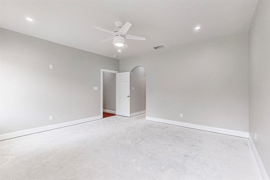 Empty room featuring concrete flooring and ceiling fan