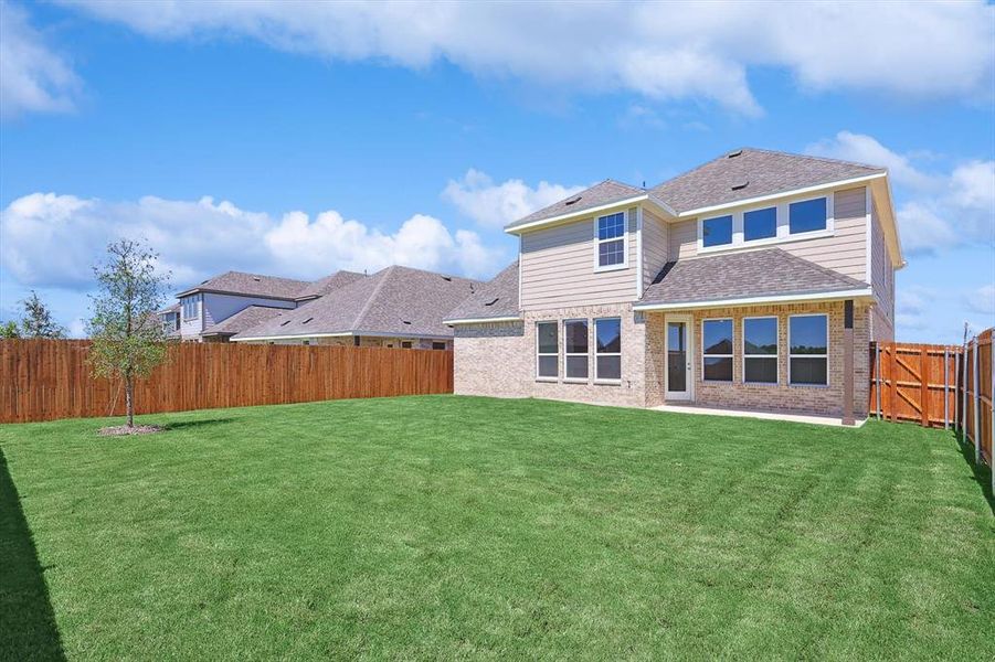 Rear view of house featuring a lawn