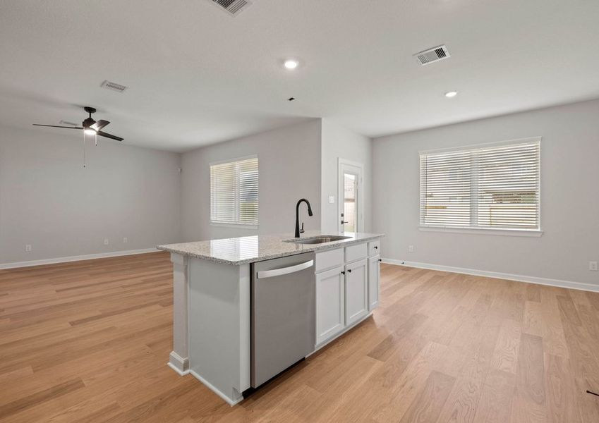 Kitchen island with a sink facing the family room.