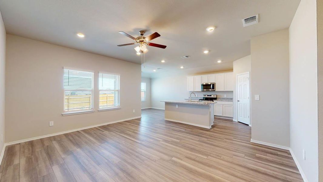 Kitchen with open floor plan, an island with sink, white cabinetry, ceiling fan, and recessed lighting