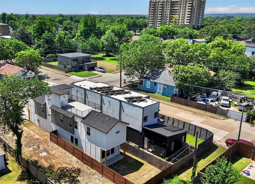Contemporary multi-level residences featuring light and dark siding, private rooftop terraces, and modern solar panels