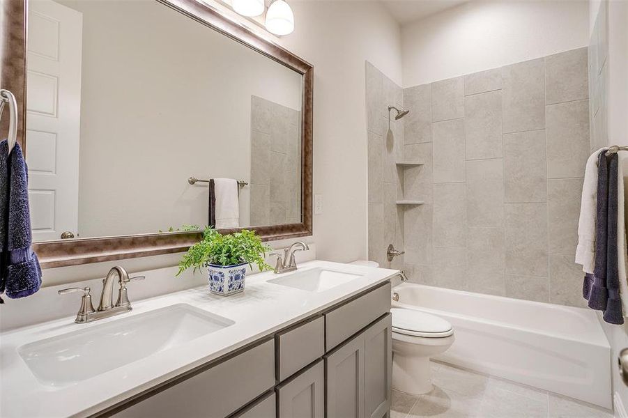 Full bathroom featuring tile patterned floors, tiled shower / bath combo, vanity, and toilet