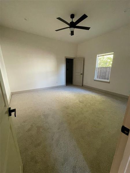 Primary bedroom featuring ceiling fan and carpet floors