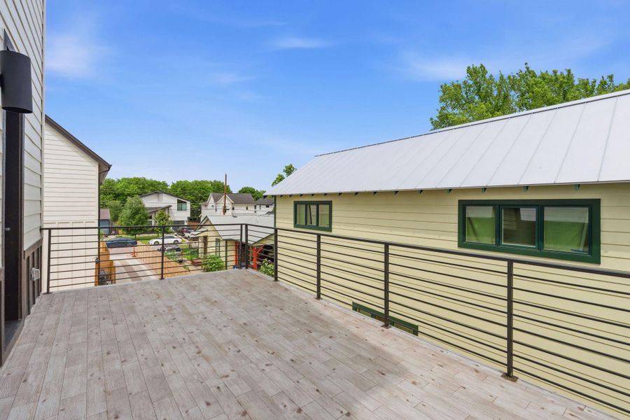 Expansive outdoor deck featuring wood-finish flooring and contemporary black metal railings