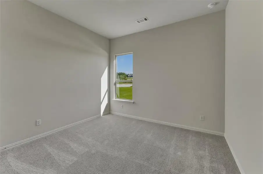 Bright interior space featuring light gray wall paint, gray patterned carpet, and a white framed window Bright interior space featuring light gray wall paint, gray patterned carpet, and a white framed window